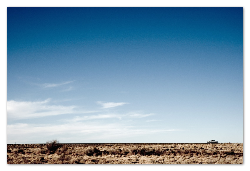 06Stock Pick up truck driving open road against blue sky Arizona