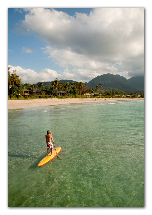 Kauai003 Man paddling surfboard Hanalei Bay Kauai Hawaii