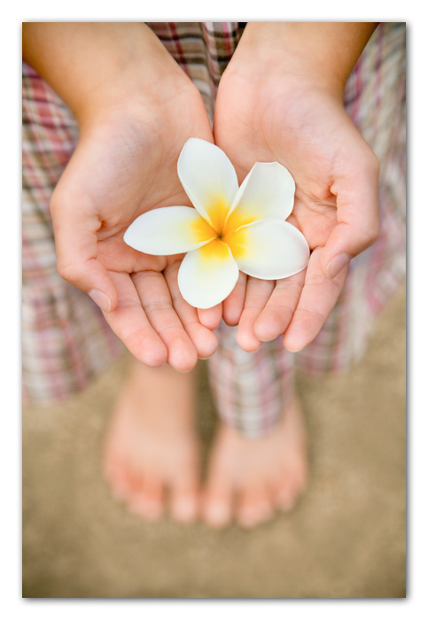 Kauai016 Close up of girl holding plameria flower Poipu Beach Hawaii